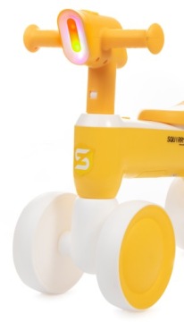 Желтый беговел, играющий на велосипеде со светом