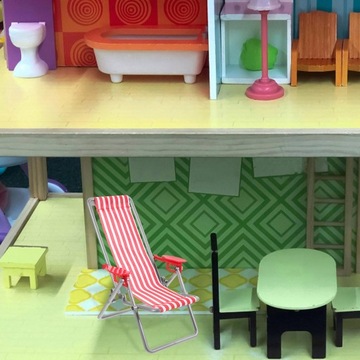 Symulowany model domku dla lalek na krześle plażowym