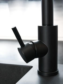 Черный кухонный смеситель с выдвижным гибким изливом.