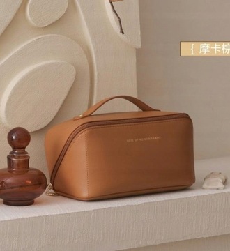 Большая женская дорожная косметичка из бежевой кожи.