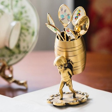 Ангел несет статую с корзиной, подставку для десертной ложки с фруктами.