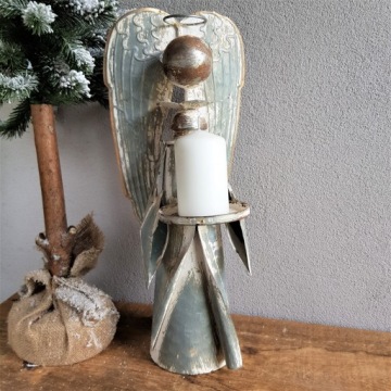 Металлический ангел держит подсвечник диаметром 46 см.