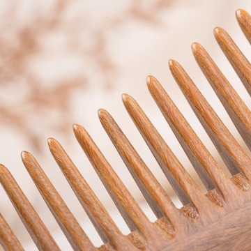 Женская расческа для волос с деревянной ручкой.