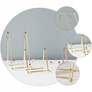 На столе стоит книга, металлический мольберт.