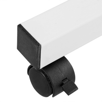 Компьютерный стол с регулируемой высотой, стоящий на столе, с передвижным диваном рядом с кроватью.