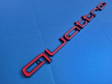 Надпись Quattro на решетке, черно-красная.