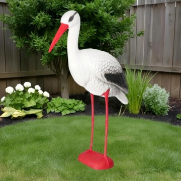 Аист, стоящий в живых садовых статуэтров