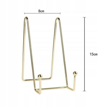 На столе стоит книга, металлический мольберт.