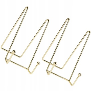 На столе стоит книга, металлический мольберт.