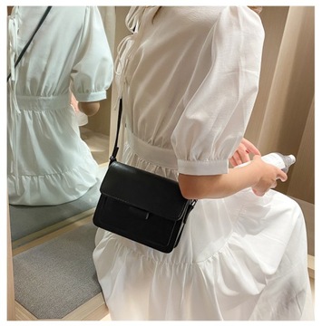 Женская маленькая сумка через плечо от модного бренда черного цвета.