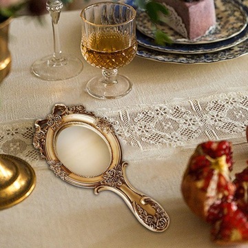 Красивое винтажное зеркало с декоративной ручкой.