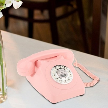 Старомодный настольный телефон розового цвета.