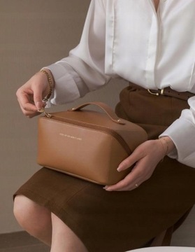 Большая женская дорожная косметичка из бежевой кожи.