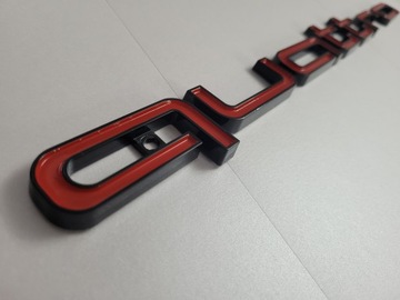 Надпись Quattro на решетке, черно-красная.