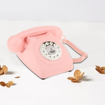 Старомодный настольный телефон розового цвета.