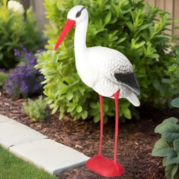 Аист, стоящий в живых садовых статуэтров
