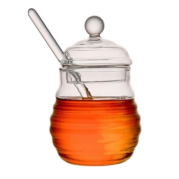 Прозрачный контейнер для меда с ложкой и крышкой.