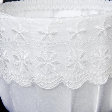 Белое атласное кружево, украшенное свадебной корзиной цветов.