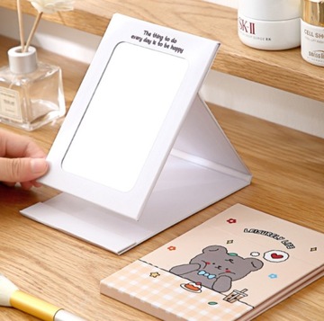 Портативное складное зеркало розового цвета.