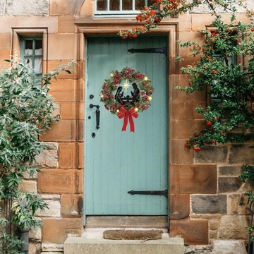 Художник собирает 2 рождественских венка с бантиками