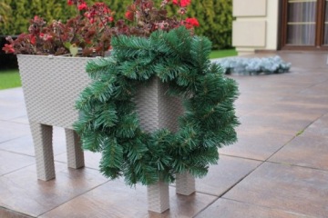 Рождественский венок на двери, толстые ветки елки.