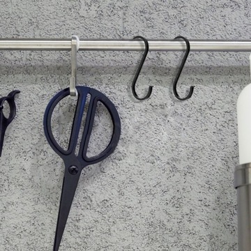 Черная вешалка для одежды S-образной формы.