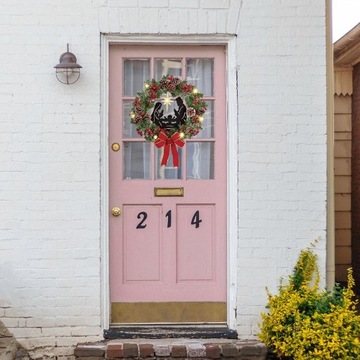 Художник собирает 2 рождественских венка с бантиками