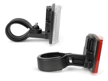 Комплект велосипедных отражателей белого и красного цвета, прикрученных к зажиму.