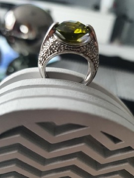 Srebrny pierścionek z dużym zielonym kamieniem.