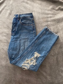 Niebieskie jeansy z dziurami i przetarciami