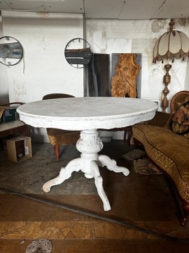 Stary piękny duży okrągły stół na rzeźbionej nodze