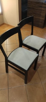Dwa czarne krzesła z beżowym obiciem
