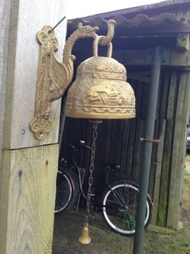 Dzwon mosiężny z reliefami zawieszany.