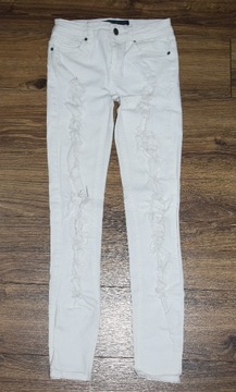 Białe spodnie skinny z dziurami Bershka 32/34