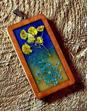 Wisiorek z suszonych kwiatów w żywicy niebiesko żółty drewniana ramą